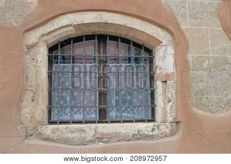 The picture was taken in the old part of Budapest called Buda. In the photo the window of an old house is behind bars.