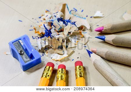 Crayons And Pencil Sharpener On A Wooden Office Table. Crayons With Sharpening Crayons And Pencils O