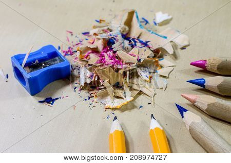 Crayons And Pencil Sharpener On A Wooden Office Table. Crayons With Sharpening Crayons And Pencils O