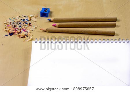 Crayons And Pencil Sharpener On A Wooden Office Table. Crayons With Sharpening Crayons And Pencils O