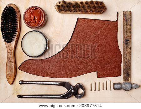 Silhoutte Of Leather Chelsea Boots In The Center With Shoe Maintenance Set And Reapir Set.top View.w