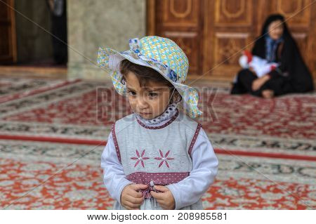 Fars Province Shiraz Iran - 19 april 2017: Shah Cheragh Shrine One unknown little girl about 4 years old in the inner courtyard of the mosque.