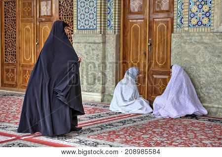 Fars Province Shiraz Iran - 19 april 2017: Parishioners sit in courtyard of Shah Cheragh Shrine mosque.