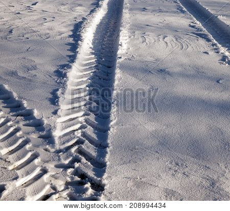 traces of a truck on white snow. close-up photo