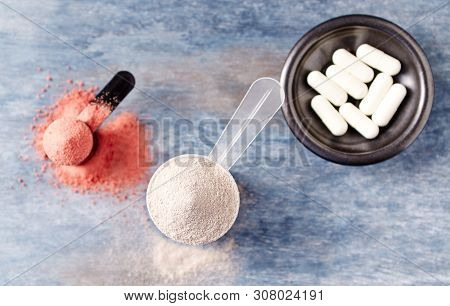 Scoop Of Whey Protein, Creatine Powder And Taurine Capsules. Sport Nutrition. Rustic Wooden Backgrou