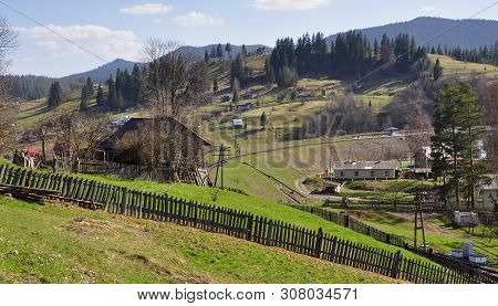Life In The Hills: Houses, Trees, Apiary, Railroad, Wooden Sheds And Hedges Under A Cloudy Sky. Brig