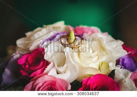 Rings Of The Bride And Groom On The Wedding Bouquet Of Roses And Eustome, Close-up