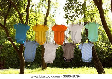 Colorful Baby Onesies Hanging On Clothes Lines Outside