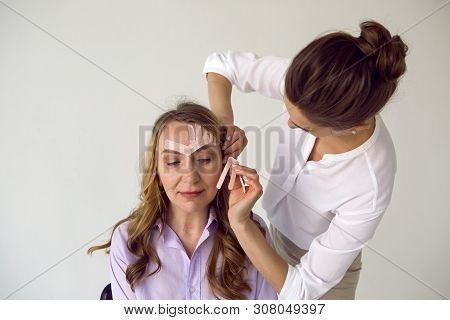 Beautician Aesthetician Glues Kinesio Tape On The Face