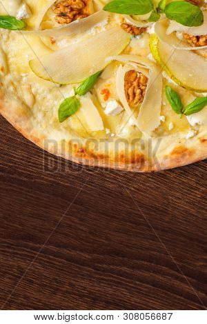 Vegetarian Italian Pizza With Nuts, Yellow Pear, Parmesan Cheese And Fresh Green Basil Leaves On A B