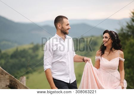 Beautiful Young Wedding Couple Standing On The Green Slope, Hill. Groom And Bride In Carpathian Moun