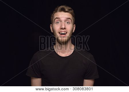 Close Up Portrait Of Young Man Isolated On Black Studio Background. Photoshot Of Real Emotions Of Ma