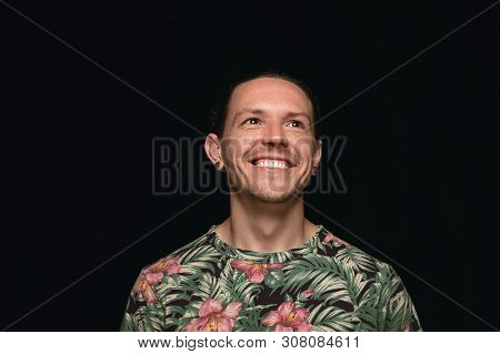 Close Up Portrait Of Young Man Isolated On Black Studio Background. Photoshot Of Real Emotions Of Ma