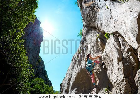 Rock Climbing And Mountaineering In The Paklenica National Park. A Woman Overcomes A Challenging Cli