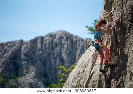 Rock Climbing And Mountaineering In The Paklenica National Park. A Woman Overcomes A Challenging Cli