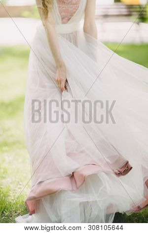 The Legs Of The Bride In A Wedding Dress In Shoes Close Op