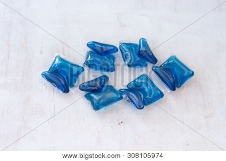 Set Of Blue Washing Detergent Capsule Isolated On White Wooden Background. Close-up.liquid Soap.