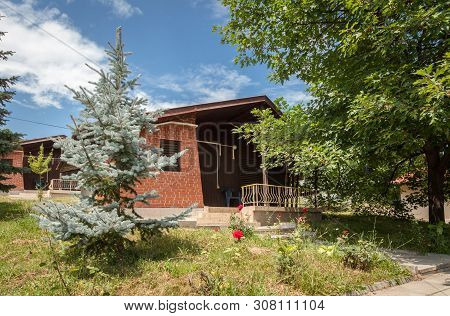 Wooden Bungalows And Garden In The Forest. Holiday Apartmens