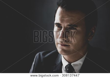 Man In Shadow With Serious Face Staring At Interlocutor In Interrogation Room