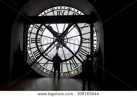 Paris, France - May 9, 2019: Famous Clock With Roman Numerals  And Silhouette Of Man Looking Into Ro