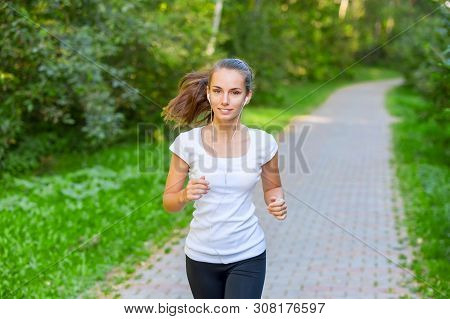 Running Girl Atletic Spotsman Trains In The Summer Park. Outdoor Fitness Portrait