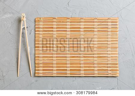 Two Sushi Training Sticks With Empty Bamboo Mat Or Wood Plate On Stone Background Top View With Copy
