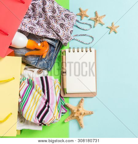 Summer Concept Of Colourful Shopping Bags Full Of Clothes. Gift Bags With T-shirt, Denim Shorts, Not