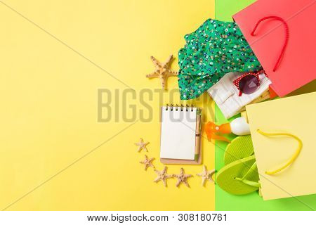 Summer Concept Of Colourful Shopping Bags Full Of Clothes. Gift Bags With T-shirt, Denim Shorts, Fli