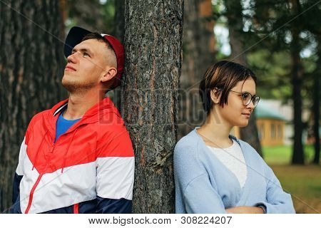 A Pair Of Teenagers: A Boy And A Girl Are Standing By A Tree, Tu