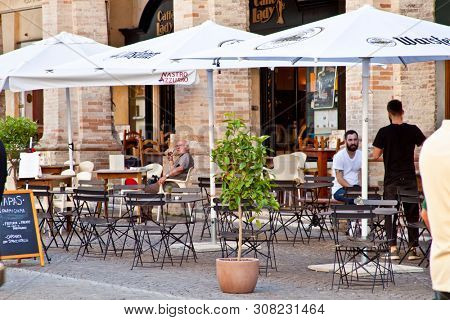 Fermo, Italy - June 23, 2019: People enjoying summer day and food at outdoor restaurant and resting, Piazza del Popolo, Fermo, Italy