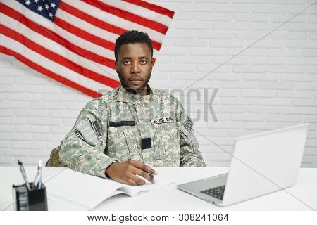 Worker Of American Army Or Soldier Sitting On Table And Watching Documents, Seriously Looking At Cam
