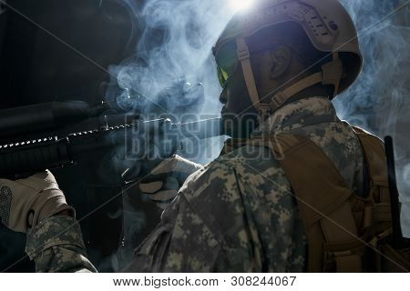 Back View Of American Ranker With Armour Confidently Standing With Weapon And Looking At Side. Afric