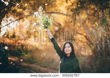 Dreamy Beautiful Girl With Thistle Flowers On Bokeh Background With Yellow Leaves. White Fluff In Go