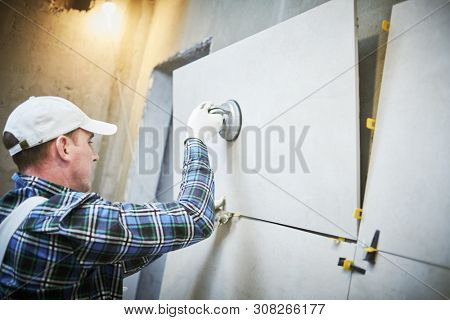 Tiler installing large format tile on wall. home indoors renovation