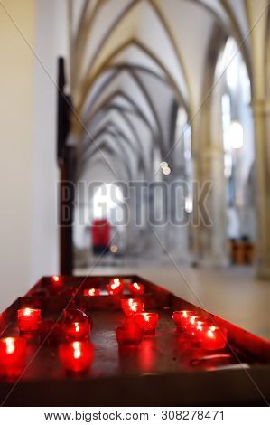 Close-up Photo Of Church Candles In Red Transparent Chandeliers In Church.