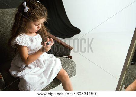 Interaction Of Children With Adult World. Cute Girl Trying To Do Bright Make Up For Being Older. Lit