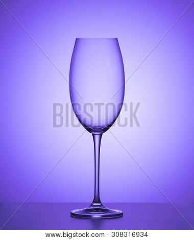 Empty Wine Glass On A Purple Background. Close Up.