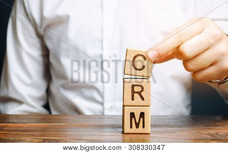 Wooden Blocks With The Word Crm (customer Relationship Management) And Businessman. Automation Strat