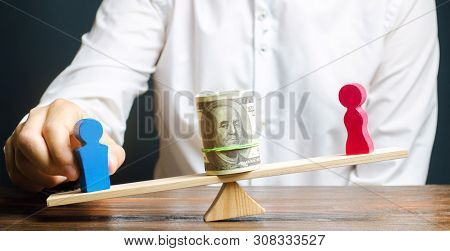 Wooden Figures Of Man And Women On The Scales. Concept Of Gender Pay Gap. Income Inequality. Oppress