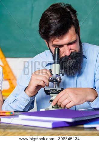 Looking Through The Microscope. Bearded Man Teacher. Back To School. Experimenting With Chemicals Or
