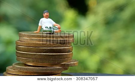 Close Up Conceptual, Midle Aged Man Enjoy His Earn Or Income, Sit At Stack Of 500 Golden Coins, With