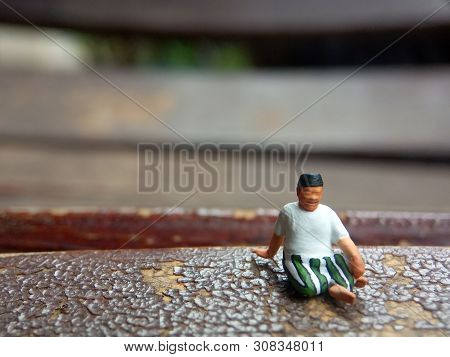 Mini Figure Toy Old Man Sit At Scratch Wooden Chair, With Copy Or Negative Space For Text Placement 