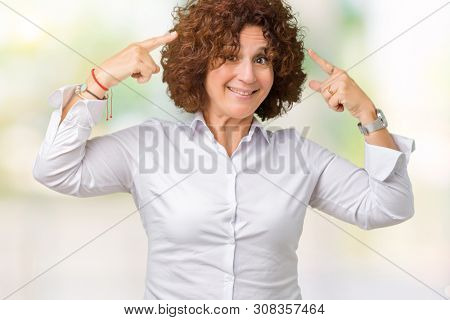 Beautiful middle ager senior businees woman over isolated background Smiling pointing to head with both hands finger, great idea or thought, good memory