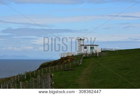 Lush Green Fields Surrounding The Coastguard Station On Fleswick Bay By The Irish Sea.