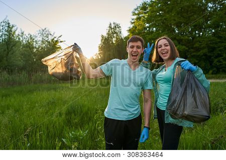 Friends Crouching With Bag Picking Up Trash Doing Plogging.plogging Concept. Boy And Girl Picking Up