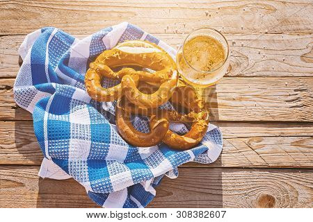 Top View On German Pretzel And Glass Of Beer In Sun. Salted Pretzel Is A Traditional German Snack Fo
