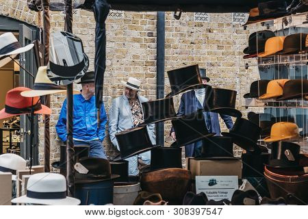 London, Uk - June 15, 2019:people Behind Hats On Sale At Stall Inside Spitalfields Market, One Of Th