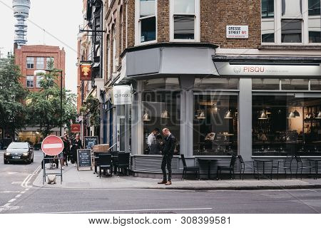 London, Uk - June 5, 2019: Man Standing And Using His Phone Outside A Restaurant In Fitzrovia, A Div
