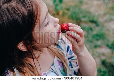 Girl Eating Strawberry. Child Face Closeup. Healthy, Organic Food. Fresh Ripe Berry. Summertime, Spr