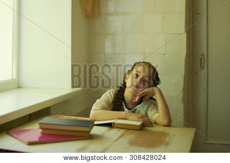 Pupil In School Uniform With Braids. Girl Schoolgirl At School With Book In School Uniform. Training